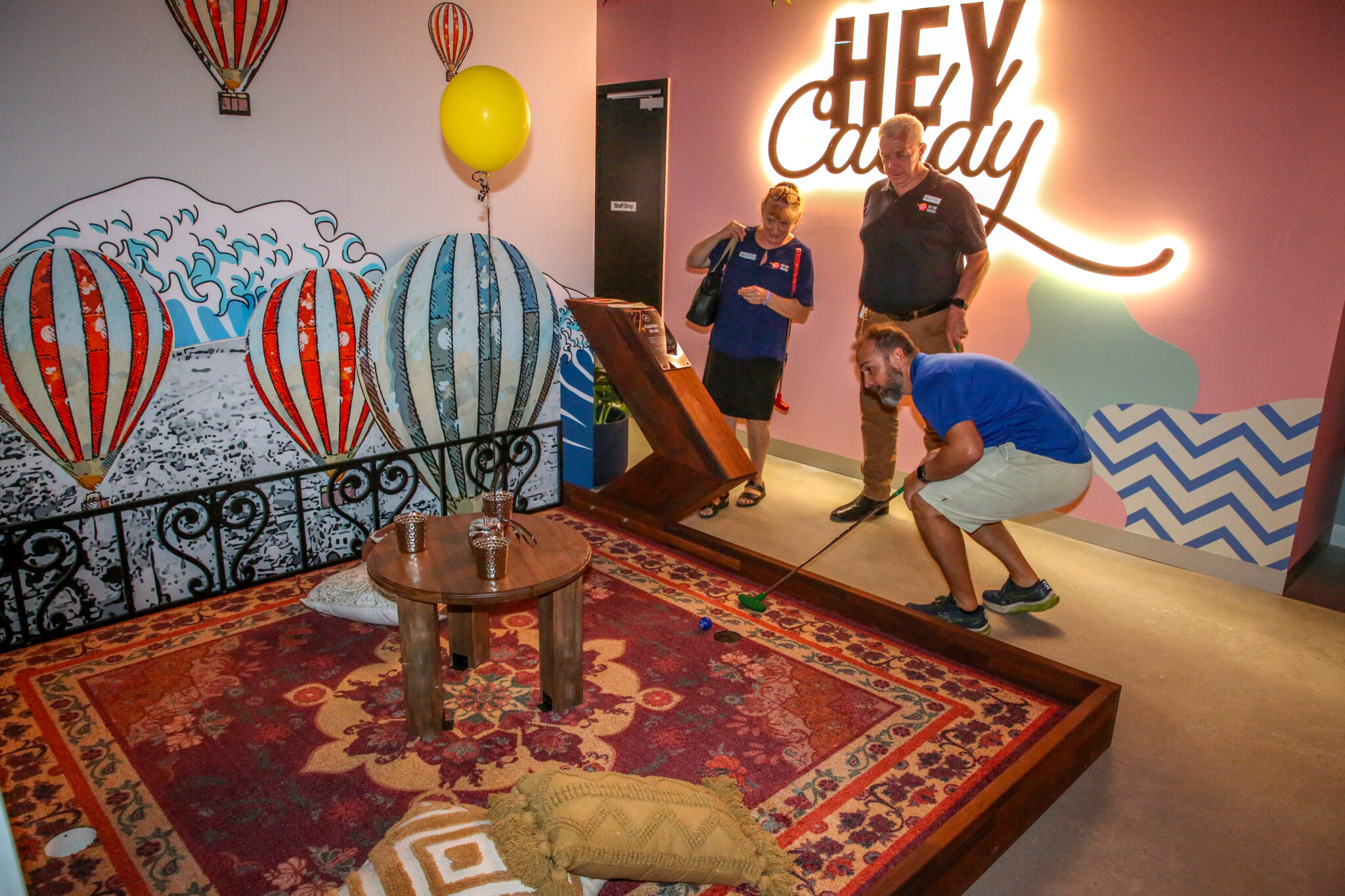 Three people enjoying mini golf at Hey Caddy Rockingham