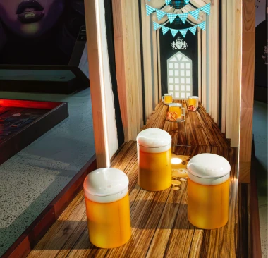 Hey Caddy mini golf course hole featuring giant beer mug obstacles on a wooden fairway