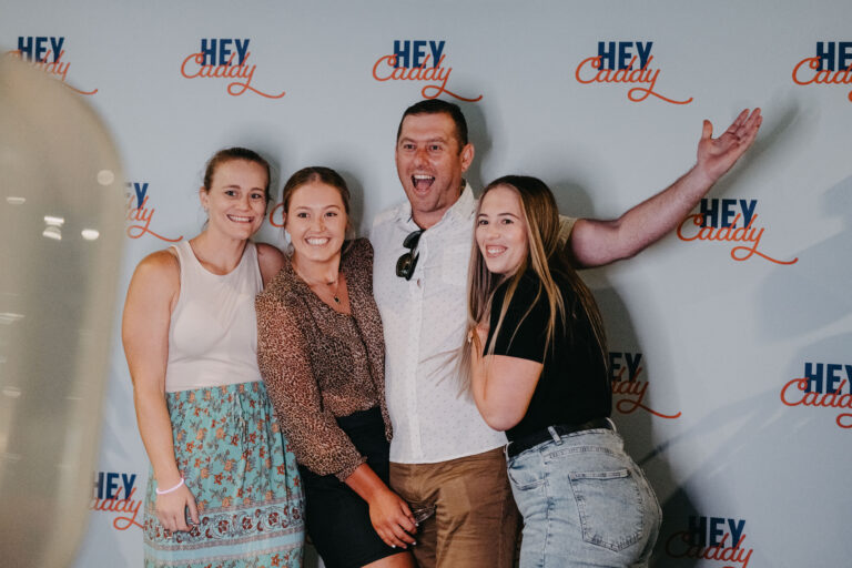 Guests posing at a Hey Caddy Macarthur event backdrop