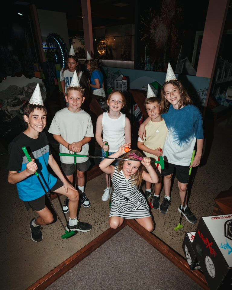 Kids enjoying enjoying indoor mini golf at Hey Caddy West Lakes in Adelaide