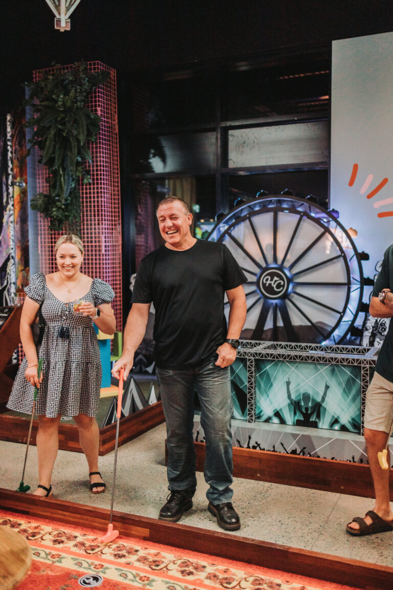 Friends enjoying indoor mini golf together at Hey Caddy Townsville