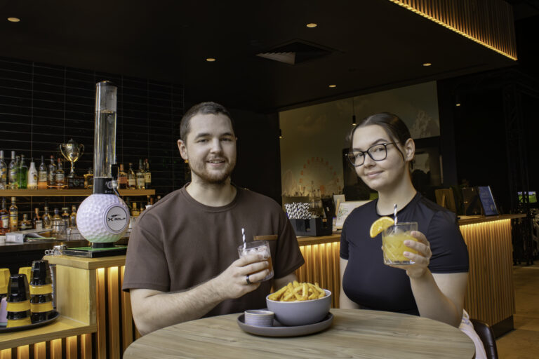 Couple enjoying drinks and food at the Hey Caddy Rockingham venue