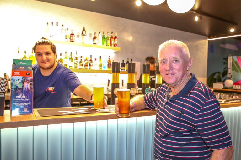 Guest enjoying a beer at the bar inside Hey Caddy Palmerston mini golf venue