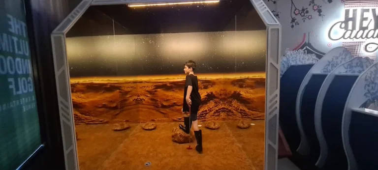 Player on a space-themed indoor mini golf course at Hey Caddy North Lakes