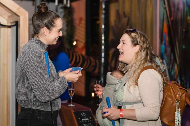 Guests chatting with mini golf clubs during a group event at Hey Caddy Preston