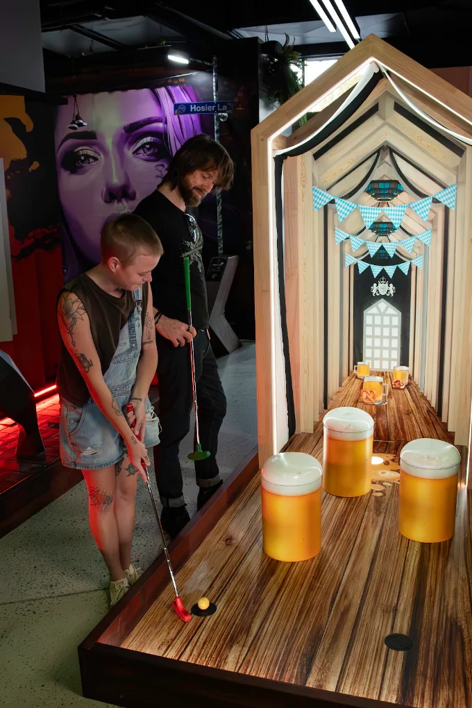 Players tackling a themed indoor mini golf hole at Hey Caddy Rockingham