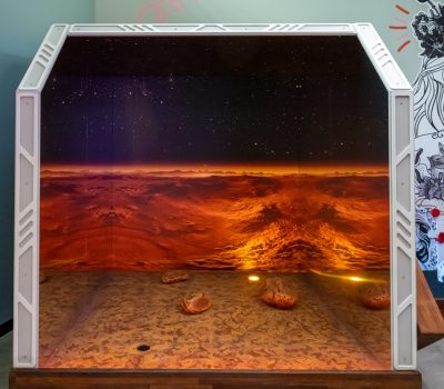 Space themed mini golf hole with Mars landscape and glowing lights at Hey Caddy