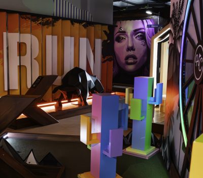 Colourful indoor mini golf course with Run themed area and neon lighting at Hey Caddy