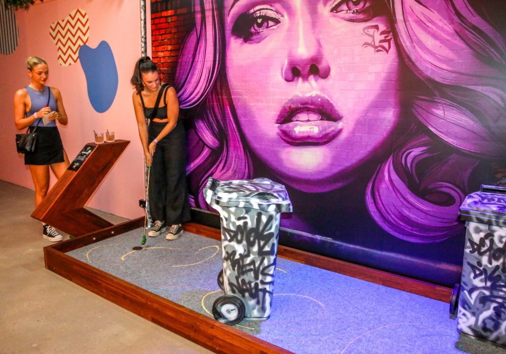 Two Women Playing Mini Golf at Hey Caddy Palmerston Venue